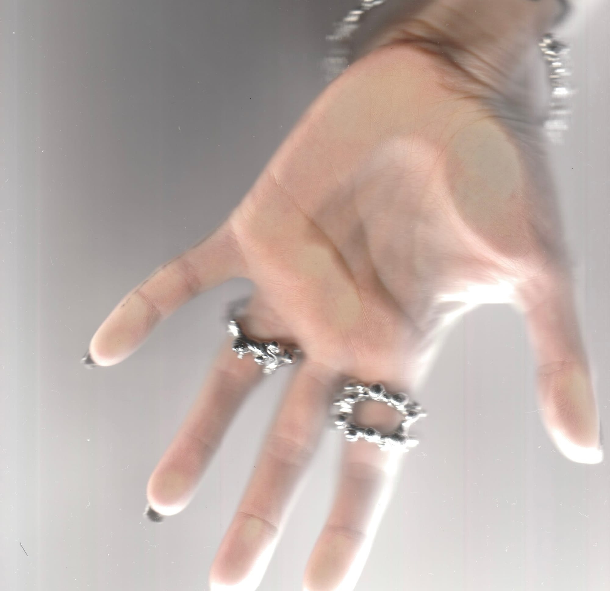 a blurred hand in motion wearing two silver rings